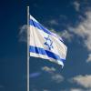 Israeli flag on flagpole against dk blue sky